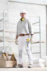 man construction worker holding tool box wear gloves, hard hat, glasses and hearing protection...