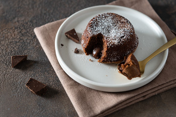Chocolate lava cake with liquid centre on dark moody background. Foundant. Restaurant menu, recipe. Side view