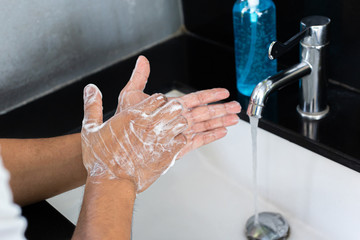 Man is washing his hands in a sink sanitizing the colona virus for sanitation and reducing the spread of COVID-19 spreading throughout the world, Hygiene ,Sanitation concept.