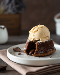 Chocolate lava cake with ice cream served on plate on dark background. Confectionery, cafe, restaurant menu, recipe, cookbook