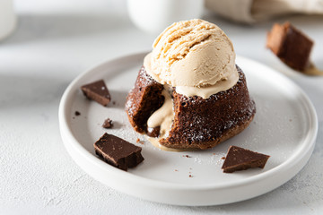 Chocolate lava cake with liquid centre on white moody background. Restaurant menu, recipe. Side view