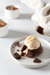 Chocolate lava cake with ice cream scoop served on plate on white background. Confectionery, cafe, restaurant menu, recipe, cookbook