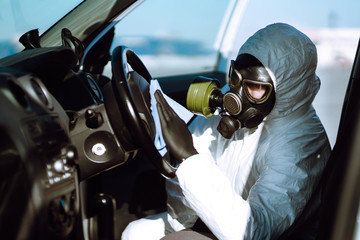 Fototapeta premium Hand of Man in protective suit washing and disinfection of the steering wheel in the car, prevent infection of Covid-19 virus, contamination of germs or bacteria. 