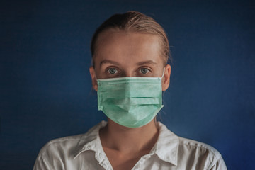 girl in a medical mask on a dark blue background