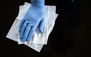 surface home cleaning spraying antibacterial sanitizing spray bottle disinfecting against COVID-19 spreading wearing medical blue gloves. Sanitize surfaces prevention in hospitals and public spaces.