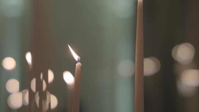 The movement along the burning candles on the background of light flare. Bokeh