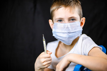 A boy in a medical bandage with a thermometer in his hand