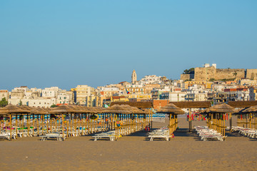 The beach equipped with umbrellas to Vieste at sunset
