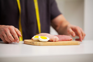 Athletic man holding a board with meat for proper nutrition of the athlete.