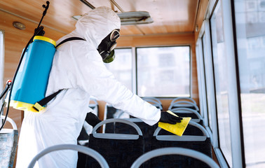 Hand of Man in protective suit washing and disinfection public transport, to preventing the spread of the epidemic of coronavirus, pandemic in quarantine city. Covid-19.
