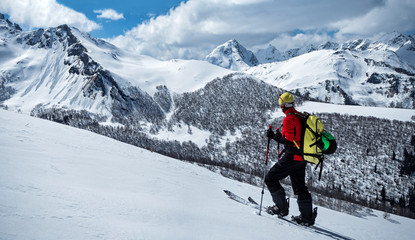 Fototapeta na wymiar Active man ski touring and climbing at winter mountains background