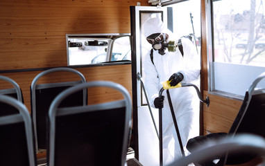 Cleaning and Disinfection public transport.Man in protective suit washing and disinfection public transport, to preventing the spread of the epidemic of coronavirus, pandemic in quarantine city. 