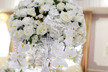 Wedding. Banquet. The chairs and round table for guests, served with cutlery, flowers and crockery and covered with a tablecloth