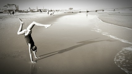 Woman Doing Handstand On Beach