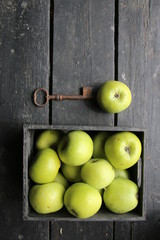 Ripe green apples box on wooden table. Top view with space for your text