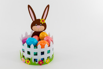 Colorful Easter eggs in a basket with an Easter bunny