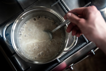Stainless steel cooking pot on gas stove in kitchen. 
