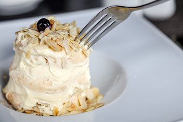 Sweet macaroon dessert on a plate with knife and fork. Cusine sweet food. Soft focus.
