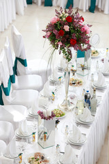 Luxury wedding reception dinning table setup with eucalyptus branches and gold geometric decoration on a rustic wooden table