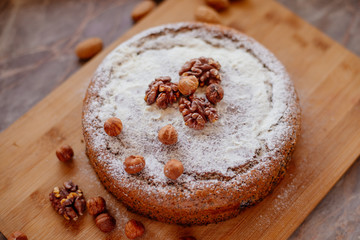 Biscuit with poppy seeds and nuts dusted with icing sugar. Homemade sponge cake with poppy seeds and nuts.
