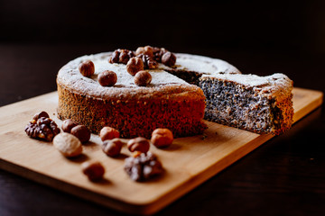 Biscuit with poppy seeds and nuts dusted with icing sugar. Homemade sponge cake with poppy seeds and nuts.