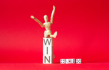 Wooden man and dice on a red background and the word victory on wooden cubes