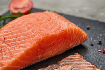 Fresh sliced salmon fillet with arugula, avocado and lemon on slate plate. Wild atlantic fish