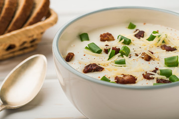 A bowl of potato soup with milk and bacon flavored with cheese and onions