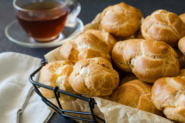 Homemade profitroles pastry filled with custard. Eclairs with cream, french dessert.