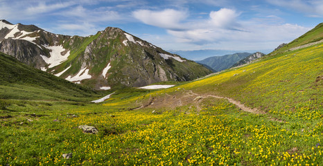 Fototapeta na wymiar Beautiful mountain valley, snow and greens on the slopes, spring in the mountains, Altay. Panoramic view.