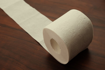Hygiene and cleanliness. Roll of white toilet paper on a wooden background