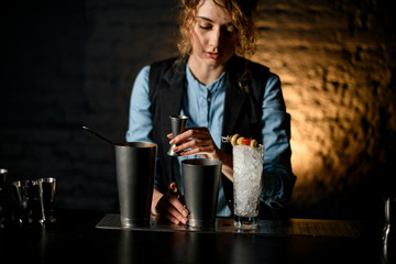 Several steel bowls and glass of ice stand on bar