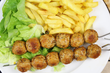 brochettes de poulet et frites dans une assiette