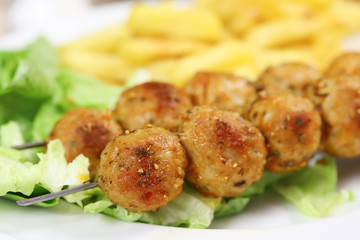 brochettes de poulet et frites dans une assiette