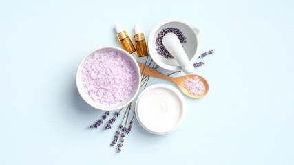 Fototapeta na wymiar Set of natural lavender cosmetic on blue background. Organic SPA beauty products for face skin treatment and body care. Flat lay, top view
