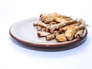Fried smelt, fish lies in a clay plate. Simple wholesome food and place to copy. Isolated item.