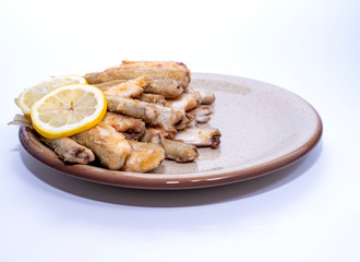 Fried smelt, fish lies on a clay plate, lemon wedges. Fresh catch, copy space