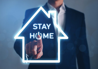 Businessman hand pointing house symbol with text Stay Home. Protection campaign or measure from coronavirus, COVID-19. Stay home text. Coronavirus, COVID-19 protection. Save your Business from home.