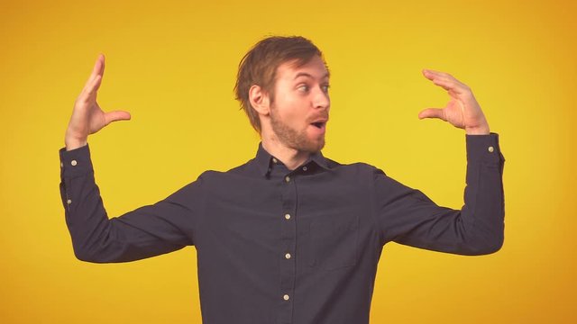Fun young man in shirt showing blah blah gesture over isolated background