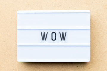 White lightbox with word wow on wood background