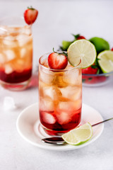 Glasses of Strawberries and Lime Ice Tea Refreshing Healthy Summer Drink Light Gray Background Vertical