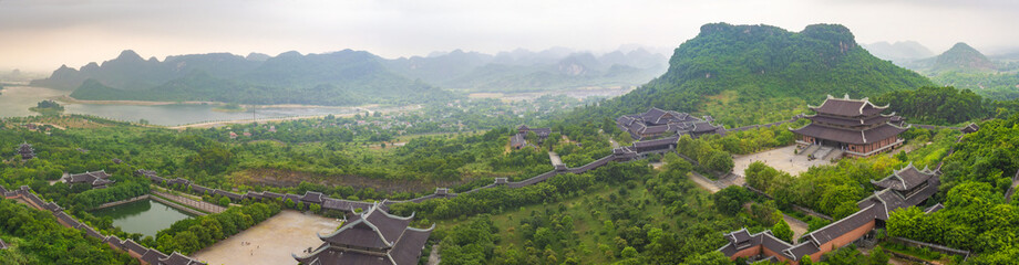Bai Dinh Temple Spiritual and Cultural Complex, is the biggest Buddhism Temple in Vietnam. It is located in Ninh Binh Province. Vietnamese foggy, hilly countryside is visible in the background.