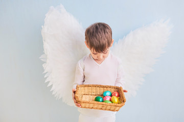 Angel boy in white with wing.Easter eggs