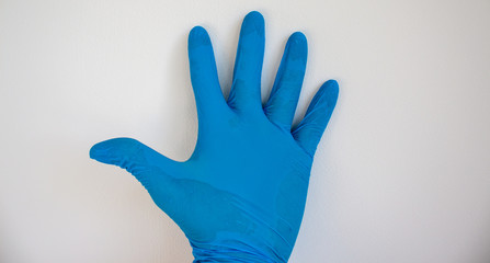 Doctor hand in sterile blue gloves. White background.