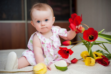 little girl 6 months old with big blue eyes in the house is happy