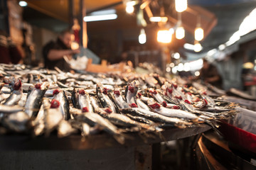 Sardine or anchovy fishes on the counter in the fish bazaar