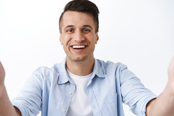 Close-up portrait of handsome kind and friendly smiling family guy, taking selfie on tablet, holding camera as talking to friends videochat during quarantine, coronavirus pandemic, staying online