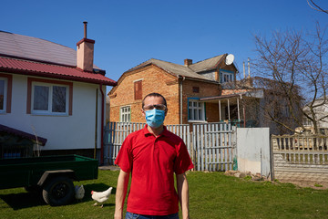 man in medical mask in the yard,man standing in his yard in summer wearing a protective mask and goggles