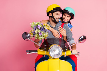 Portrait of his he her she nice attractive lovely cheerful cheery guys driving moped spending romantic day enjoying carrying flowers 8 March isolated over pink pastel color background