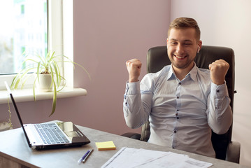 Close up of caucasian business man works happy and raising his arms up to celebrate success or achievement at home or in the office